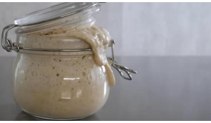 Sourdough starter spilling out of jar